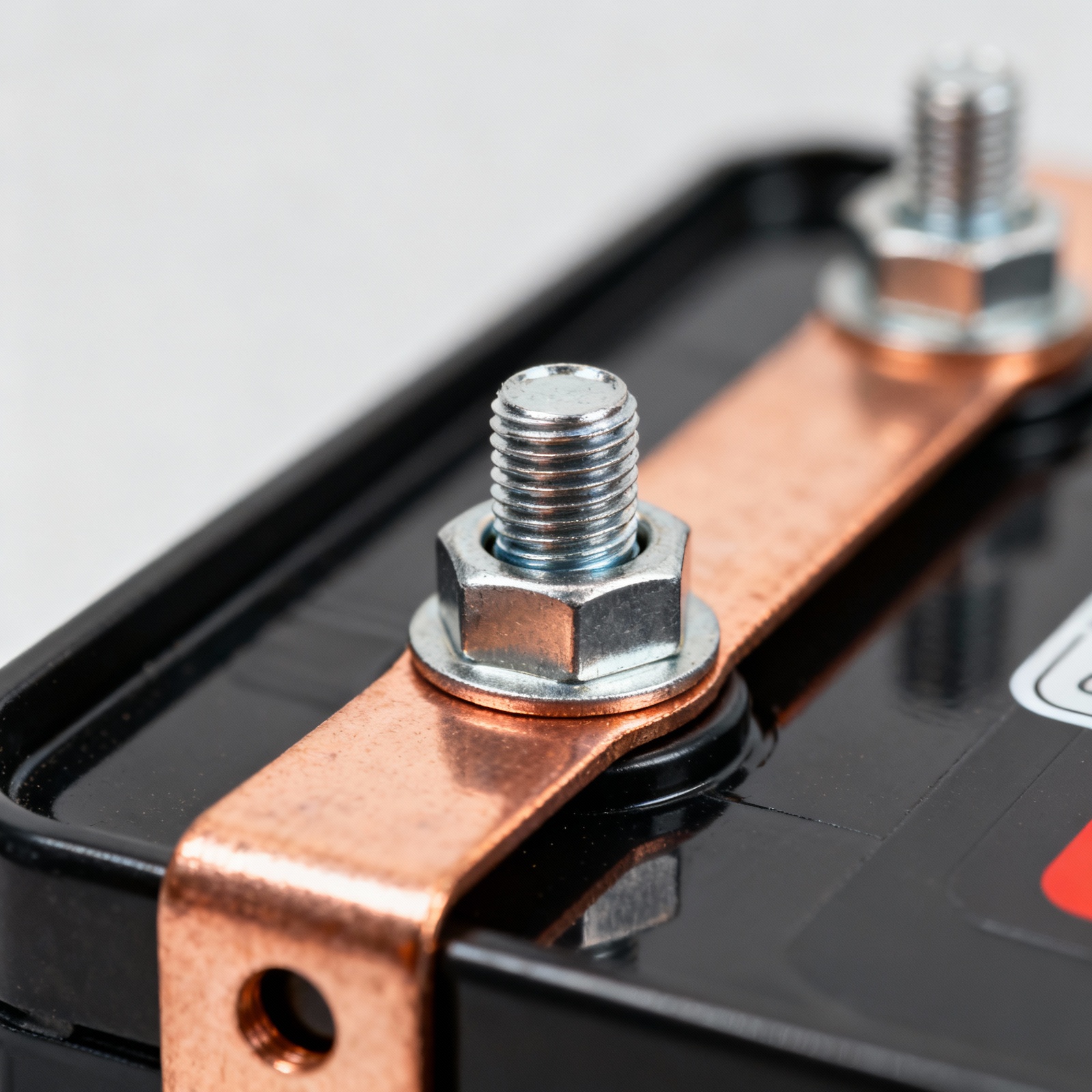 Macro close-up of LiFePO4 battery terminal connection with copper bus bar